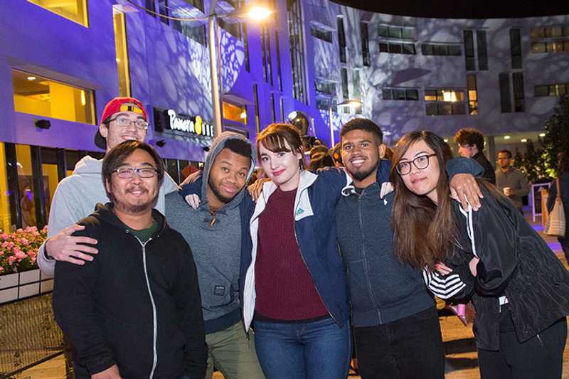 Photo of a group of Case Western Reserve University students huddled together, posing, in Uptown Cleveland